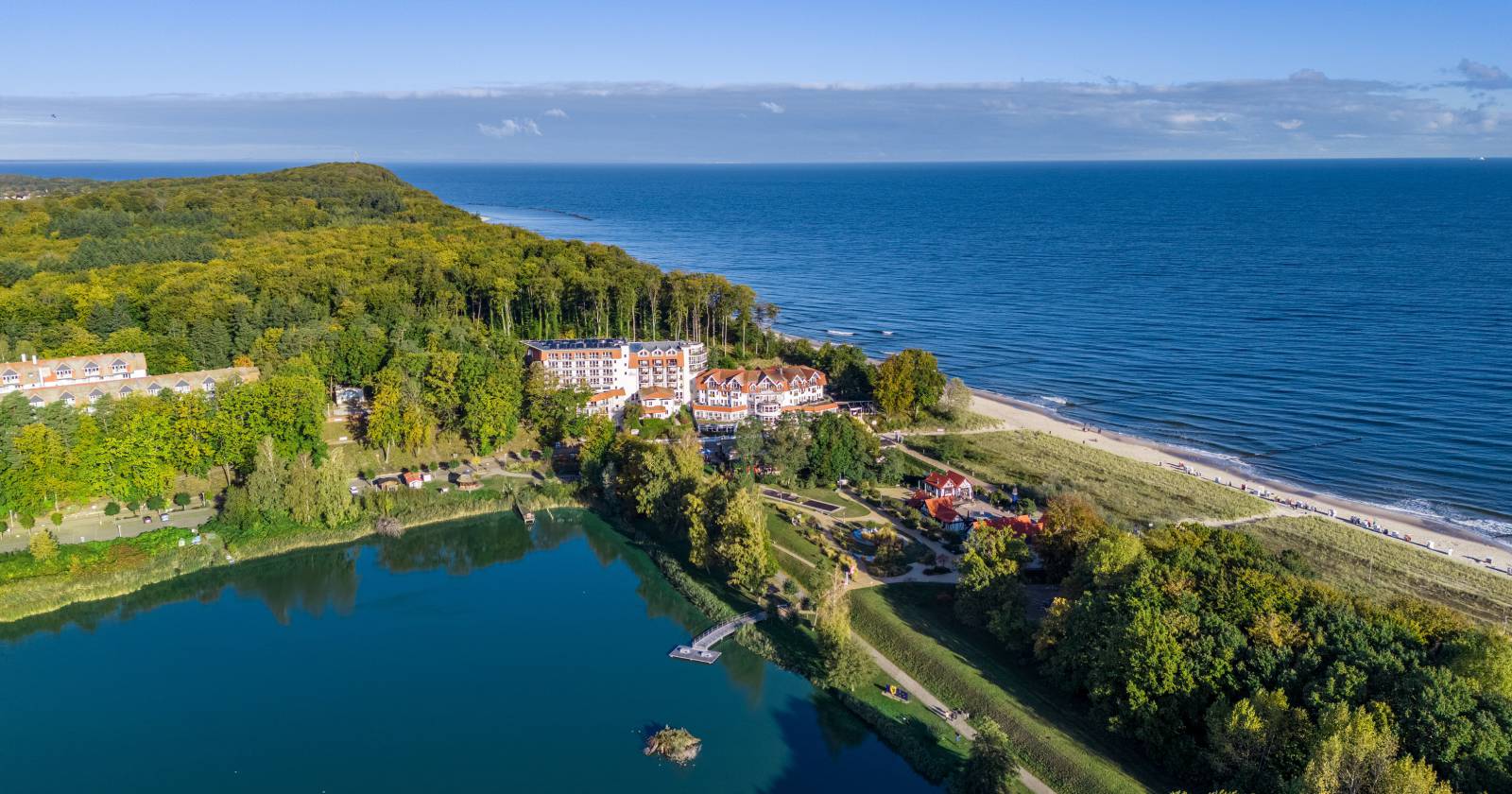 Luftaufnahme vom Stranhotel Seerose und der Ostsee mit Blick auf den Koelpinsee