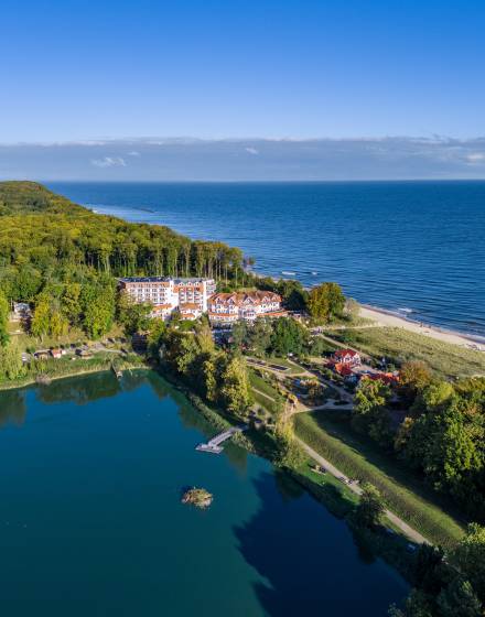 Luftaufnahme vom Stranhotel Seerose und der Ostsee mit Blick auf den Koelpinsee