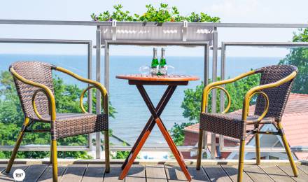 Balkon mit Tisch und Stühlen mit Blick aufs Meer